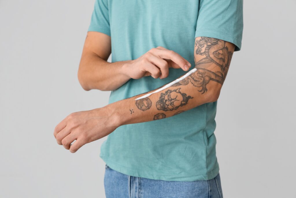 A man applies cream on his tattoo