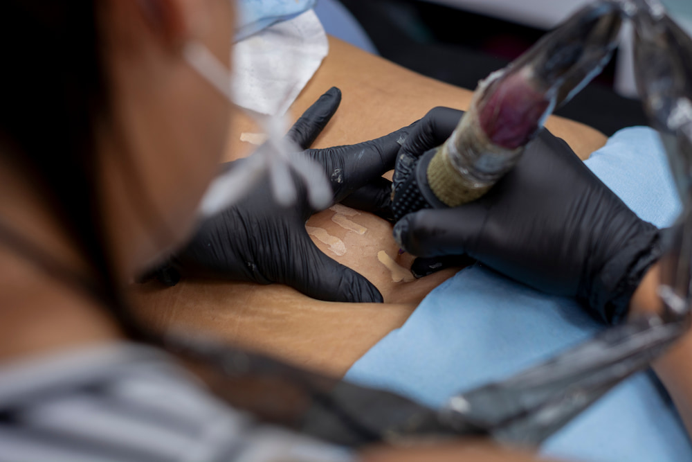 A woman tattooing over stretch marks