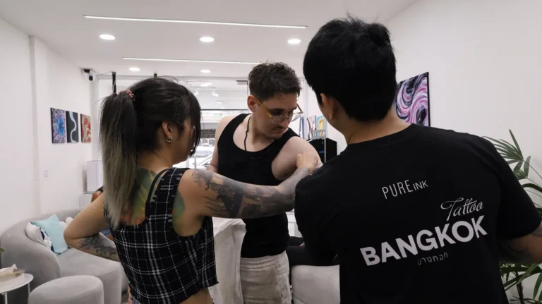 Client reviewing a tattoo artist portfolio at PUREink. Tattoo Bangkok